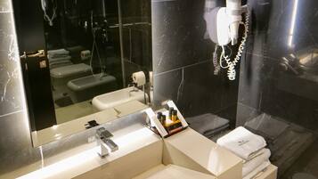 Un baño moderno con un espejo grande, lavamanos dobles y un perchero para toallas.