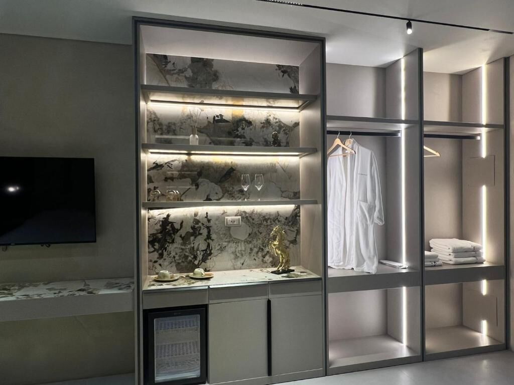 Une salle de bain moderne avec un meuble-lavabo en marbre, un miroir et un téléviseur intégré.