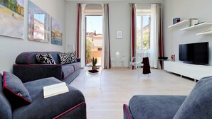 A modern living room with a sofa, a TV, and artwork on the wall. - Piazzetta Margutta - B3 (Rome)