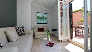 A modern living room with a sofa, a coffee table, and a potted plant. - Piazzetta Margutta - A12 (Rome)