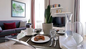 Un soggiorno moderno con un divano, un tavolino, una TV e una libreria.