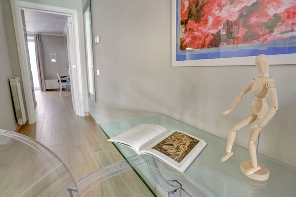 A room with a glass display case containing a book and a wooden mannequin.