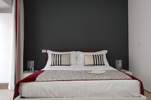 Una cama bien hecha con una colcha estampada, dos almohadas y un libro sobre la cama.