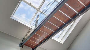 Een dakvenster met houten balken en metalen frames.
