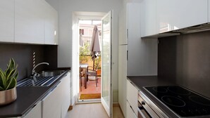 A compact kitchen with a built-in stove, a sink, and a potted plant. - Piazzetta Margutta - B6 (Rome)