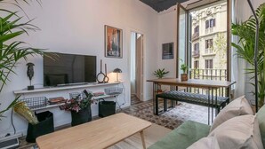 Ein gemütliches Wohnzimmer mit Fernseher, Büchern und Pflanzen.