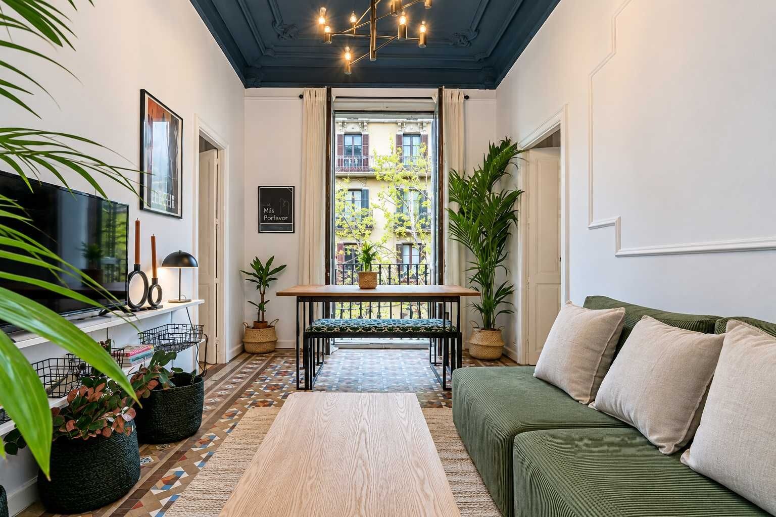 A cozy living room with a sofa, a wooden coffee table, a TV, and a dining table with chairs.