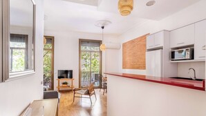 Eine moderne Küche mit weißen Schränken, einer roten Arbeitsplatte und einer eingebauten Mikrowelle.