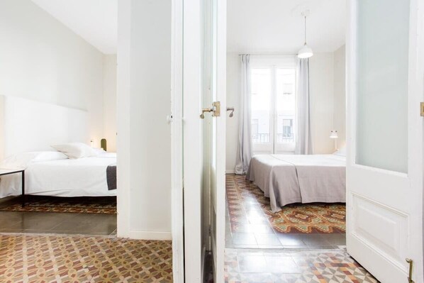 Une chambre d’hôtel avec un lit, une table de chevet et une fenêtre avec des rideaux.