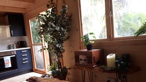 Eine gemütliche Küche mit Holzschränken, einem Einbauofen und einem großen Fenster mit Blick auf Grünfläche.
