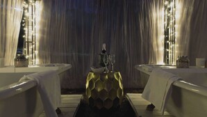 Een wellnessruimte met twee baden, een decoratief middelpunt en sfeerverlichting.