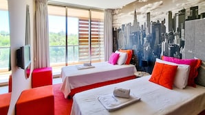 A hotel room with two beds, a TV, and a cityscape mural. - FLH Salgados Family Apartment (Albufeira)