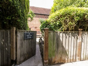 A wooden gate with a sign reading "6A Hock-Tide Cottage."