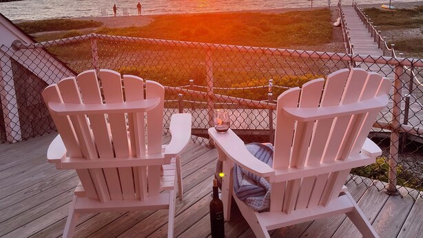 A deck with two Adirondack chairs facing a sunset over the ocean. - Spectacular Montauk Sunset in Gated Community - Perfect for Families! (Montauk)