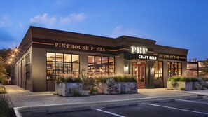 A brick building with a sign for 'Pinthouse Pizza' and 'Craft Beer'. - Cozy Boho Guesthouse + Rooftop Deck in the Trees (Austin)