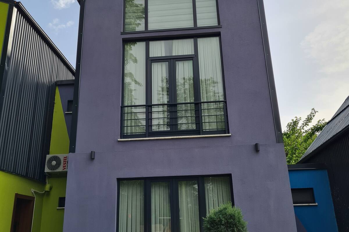 En modern byggnad i två våningar med stora fönster och ett platt tak.