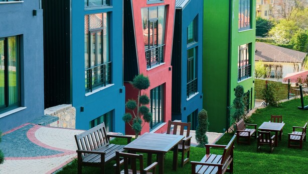 A modern building with colorful facades and a grassy outdoor area with seating. - Kartepe Loft (Kartepe)