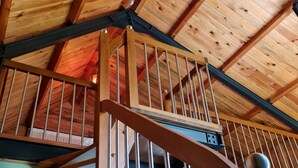 A wooden staircase with metal railings leading to a high ceiling with exposed beams. - Kartepe Loft (Kartepe)