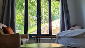 A hotel room with a large window, a sofa, a bed, and a small table. - Kartepe Loft (Kartepe)