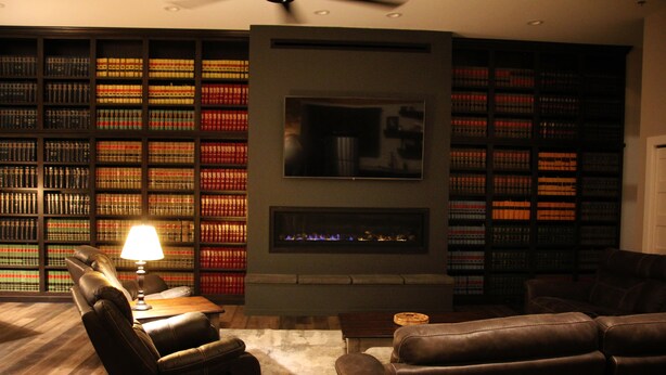 A library with leather chairs, a fireplace, and bookshelves. - The Lawft, Suite 1,  Essentially 4 bedrooms each with attached Bathroom,No pets! (Russell)