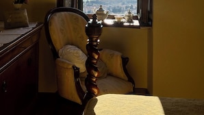 A room with a view of a landscape through an open window, a chair, a table with a teapot, and a vase with flowers. - Villa with panoramic pool • Passignano sul Trasimeno, Umbria (Passignano sul Trasimeno)