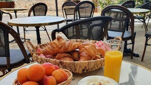 A table with croissants, a basket of oranges, and a cup of coffee. - Vilajoun (Joucas)