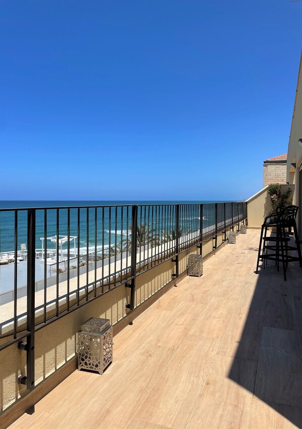 A balcony with a view of the ocean, a railing, and outdoor furniture. - Seafront penthouse - terrace, AC, lift & parking (Tel Aviv-Yafo)