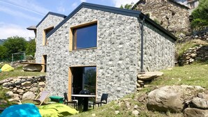 A stone house with a large window and a door, surrounded by rocks and grass. - COTTAGE Elena by KlabHouse-4pax w/AC & Lakeview  (Dolo)