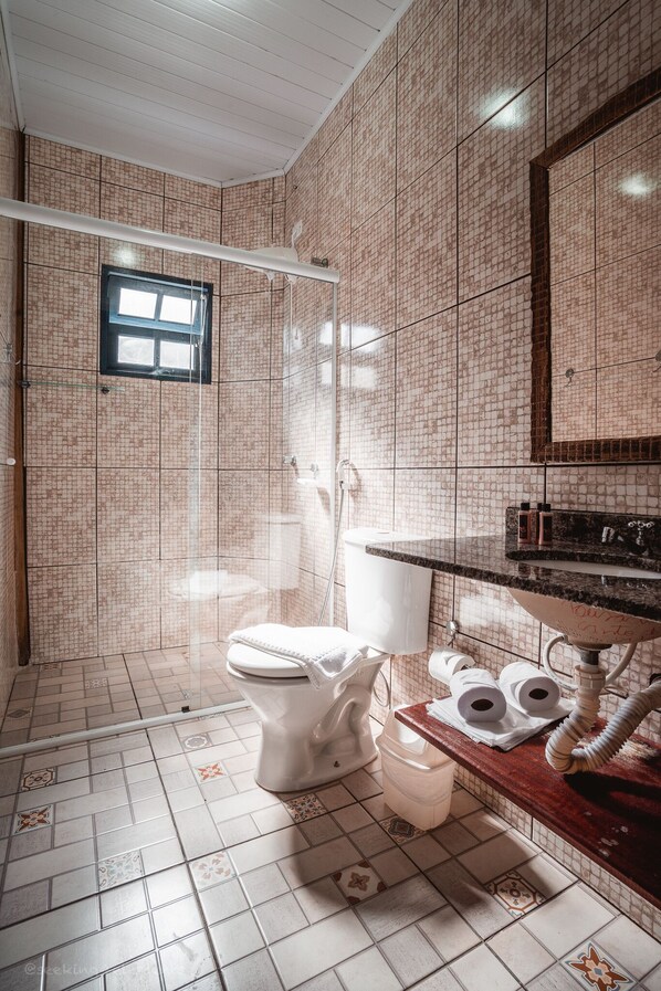 Un baño con ducha, inodoro y lavamanos.