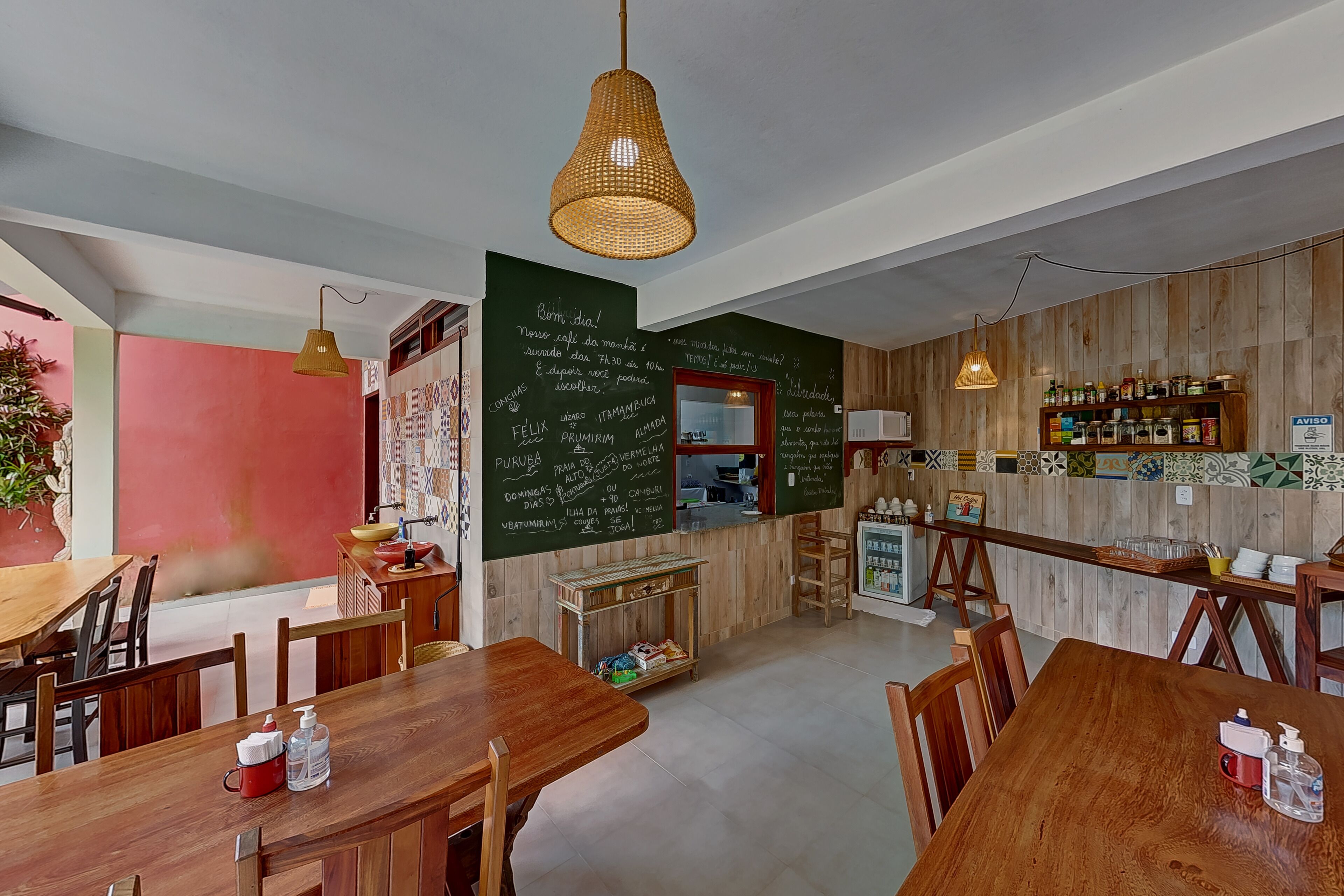 Un restaurante con mesas y sillas de madera, un menú en una pizarra y una zona de bar.