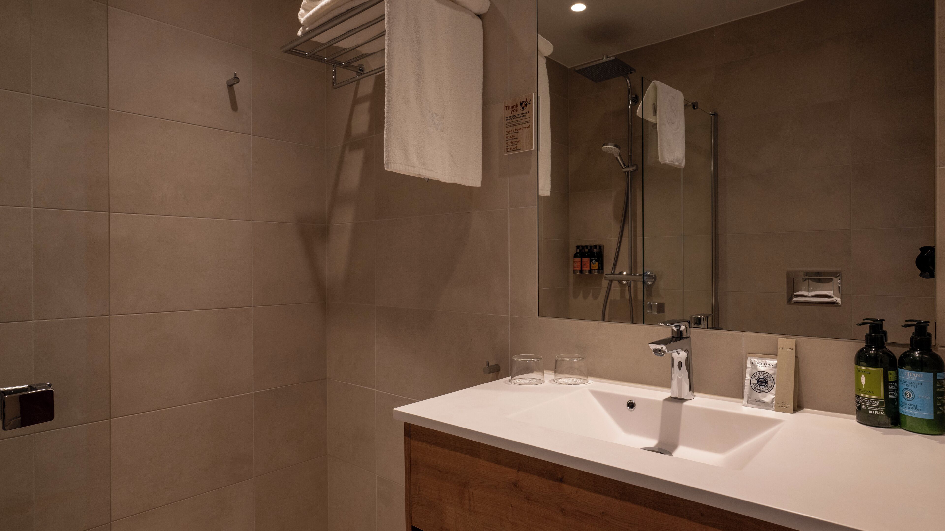 Un baño con ducha, lavabo y espejo.