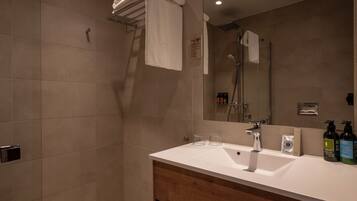 Un baño con ducha, lavabo y espejo.