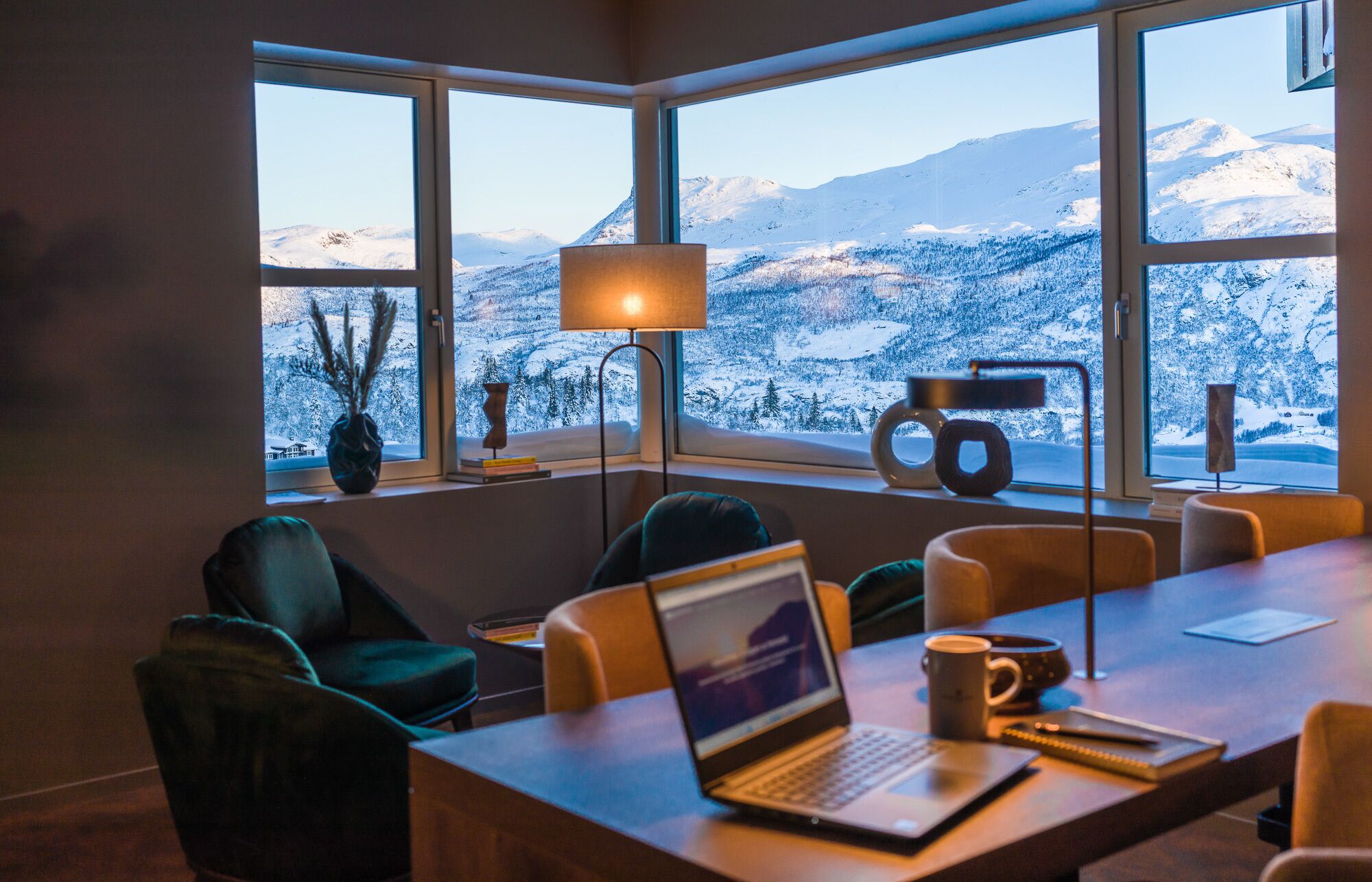 Quarto moderno com uma janela ampla que dá para uma paisagem nevada de montanha.