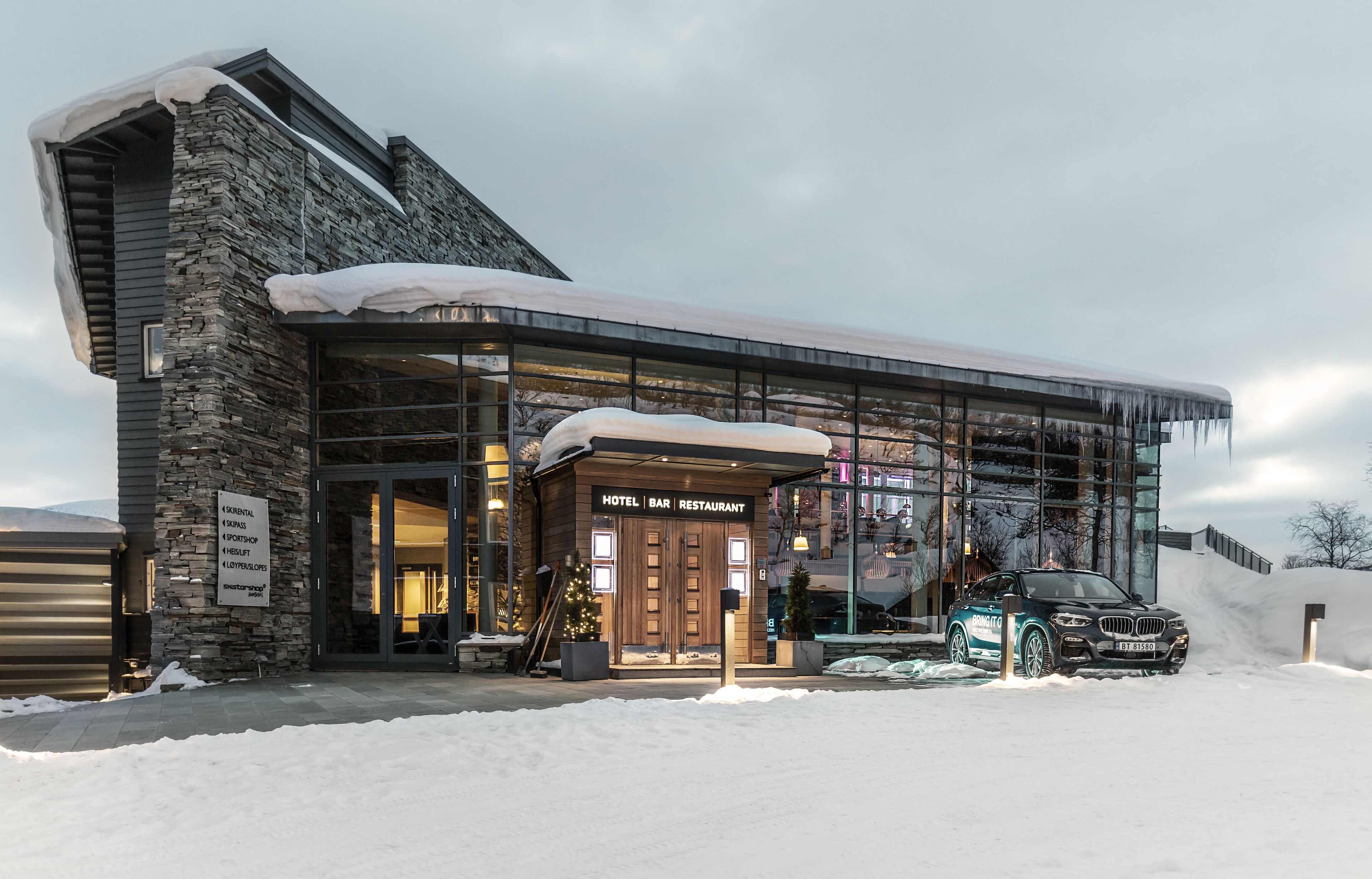 A modern building with a stone facade and a glass entrance.