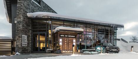 A modern building with a stone facade and a glass entrance.
