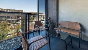 Ein Balkon mit Tisch, Stühlen und einer Sitzbank.