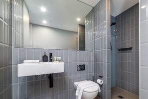 Ein modernes Badezimmer mit Waschbecken, Toilette und Duschbereich.