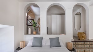 A modern bedroom with a large bed, two bedside tables, a mirror, and a wardrobe. - Líbere Málaga La Merced (Málaga)