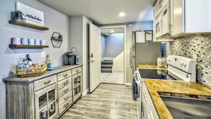 Una cocina moderna con armarios de madera, microondas integrado y salpicadero de azulejos.