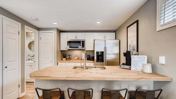 A compact kitchen with a central island, bar stools, and modern appliances.