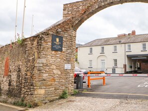 Un arc en pierre surmonté d’une enseigne indiquant qu’il s’agit d’un parking réservé aux clients de l’hôtel.