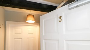 A white door with a brass number "3" and a hanging light fixture above it. - 3 Kings Mews (Richmond)
