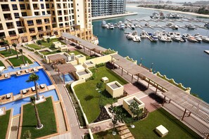 A resort with a swimming pool, landscaped gardens, and a marina with boats.