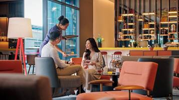 A modern interior with seating areas, a bar, and large windows.