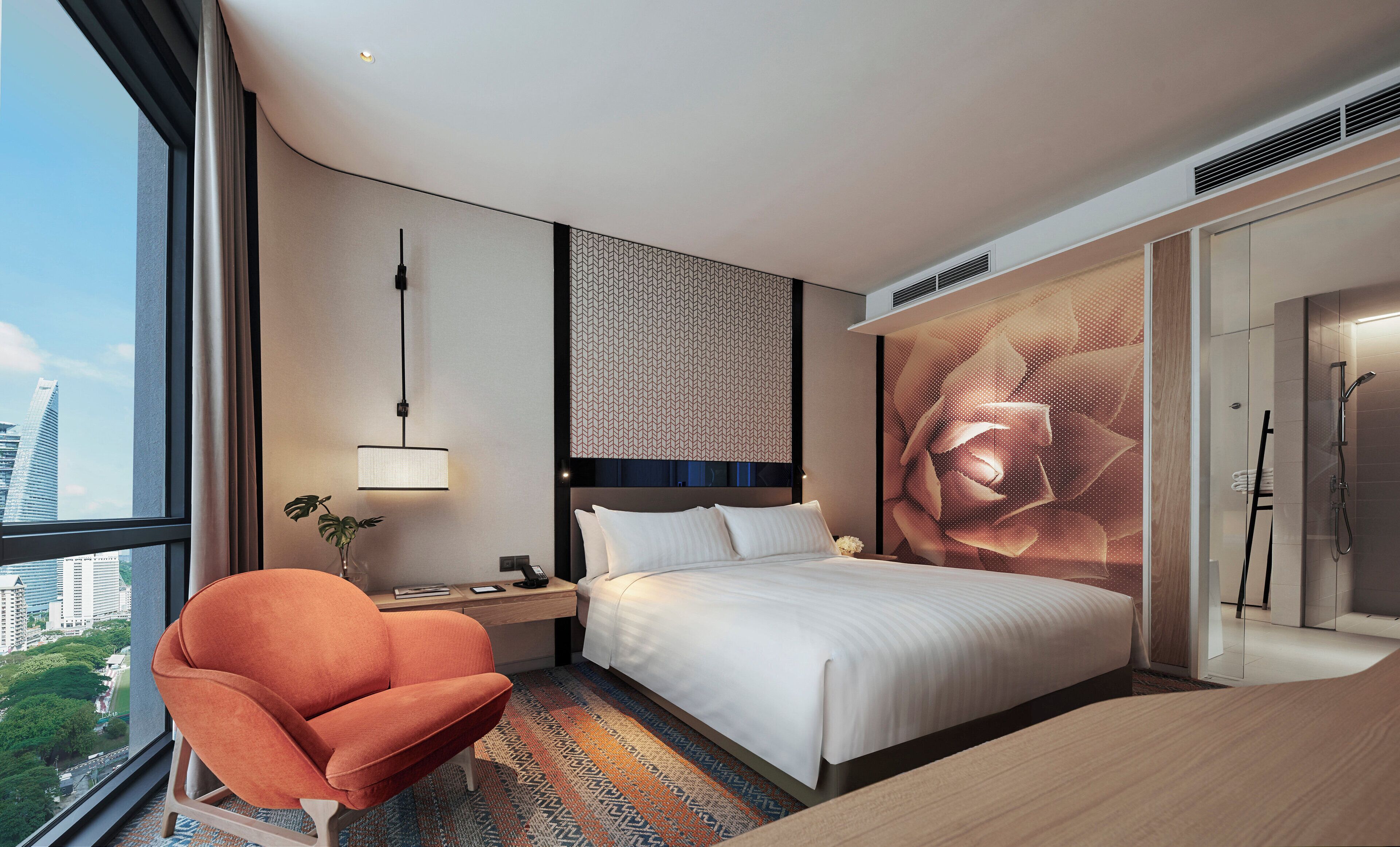 A modern hotel room with a large bed, a desk, a chair, and a large window offering a city view.