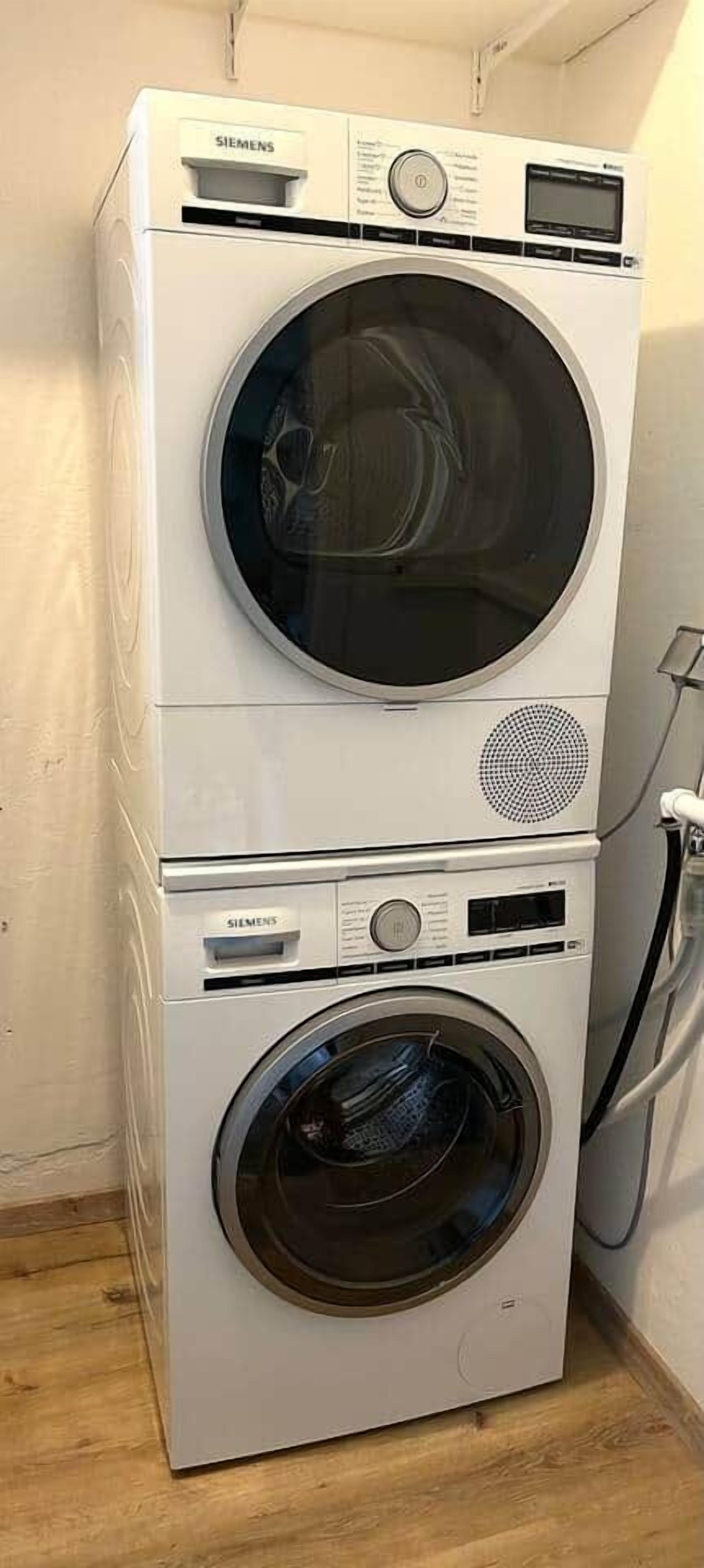 A stacked washer and dryer unit with a control panel and a power cord.
