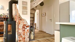 Una cucina moderna con parete in mattoni, piano cottura nero e pavimento in legno.