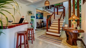 A modern interior with a wooden staircase, a bar area, and a dining space. -  Pousada Vila Galea (Itacaré)