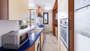 A modern kitchen with a built-in microwave, oven, and sink. - A Casa di Anna - Giuseppe by BarbarHouse (Vieste)