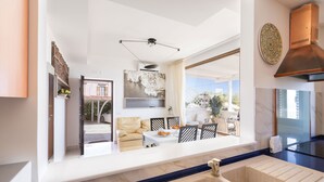 A modern kitchen with a large sink, a dining area with a table and chairs, and a view of the outside. - A Casa di Anna - Giuseppe by BarbarHouse (Vieste)